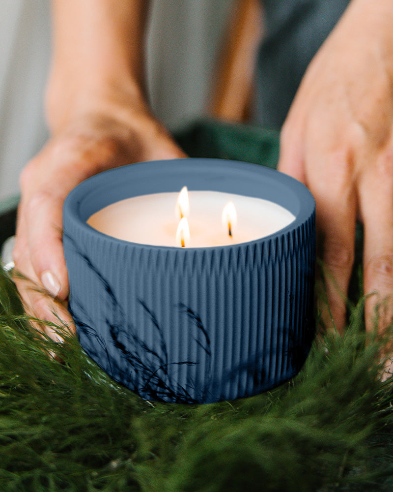 A Dark Blue colored 3-Wick Ceramic Candle scented like River Moss & Teakwood.