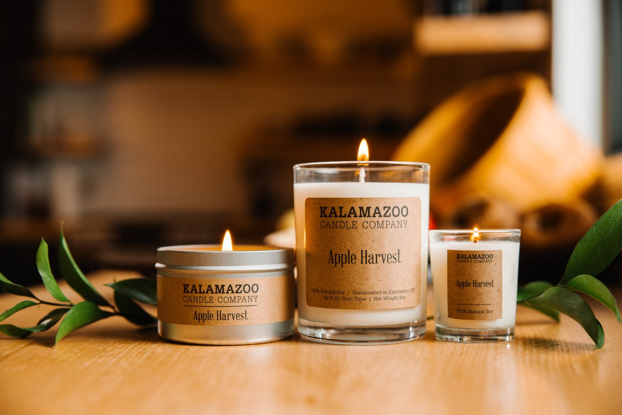 Three Apple harvest candles on a wooden table