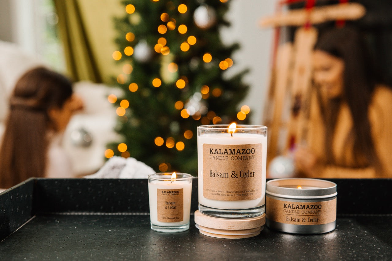 Three Balsam & Cedar Candles in front of a Christmas tree