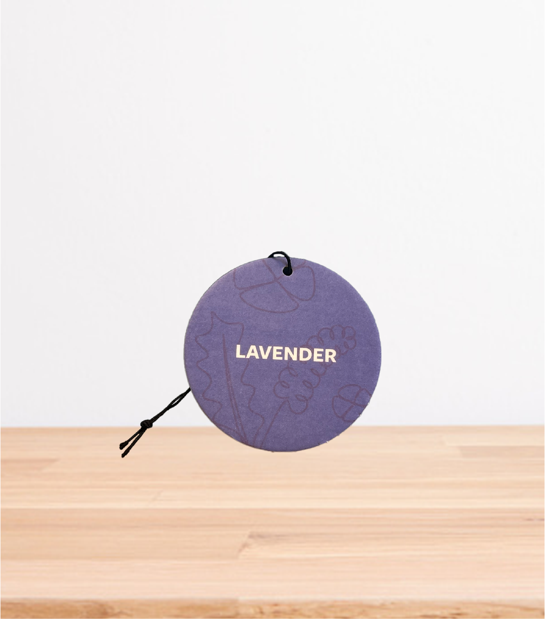 A Lavender car freshener on a wooden table