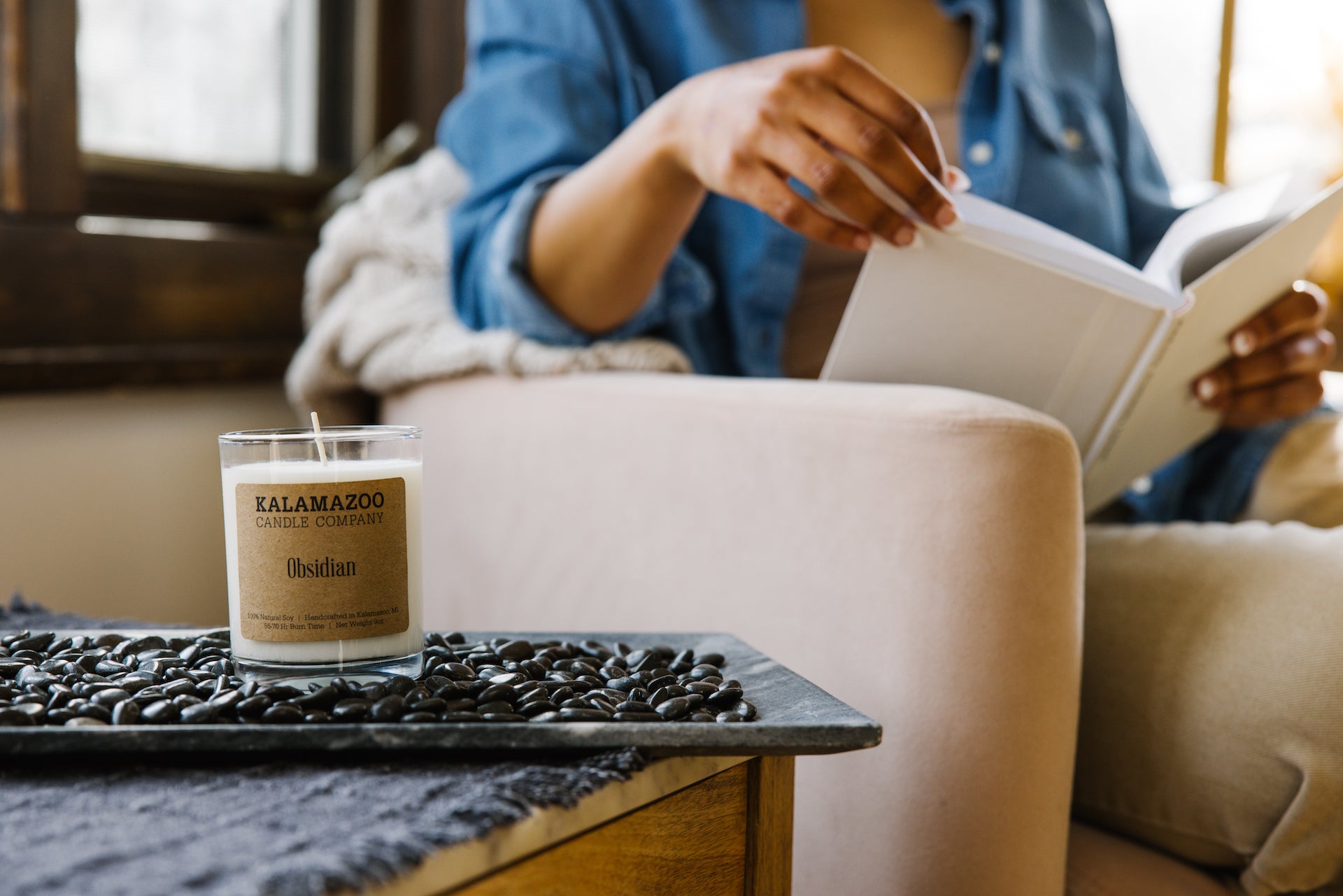An obsidian candle on a bed of obsidian rocks