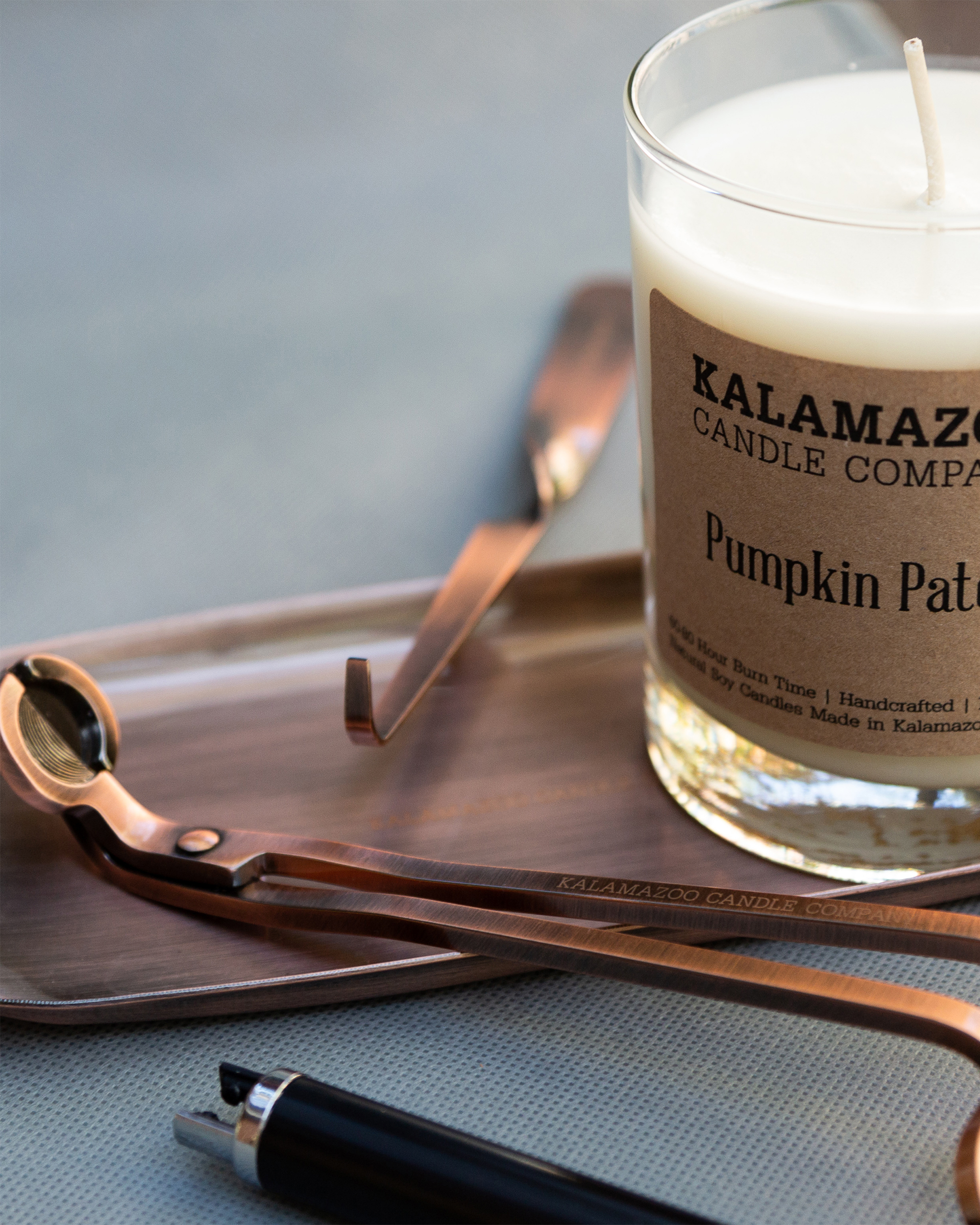A Copper Accessory Tray With Copper Tools and a Pumpkin Patch Candle.