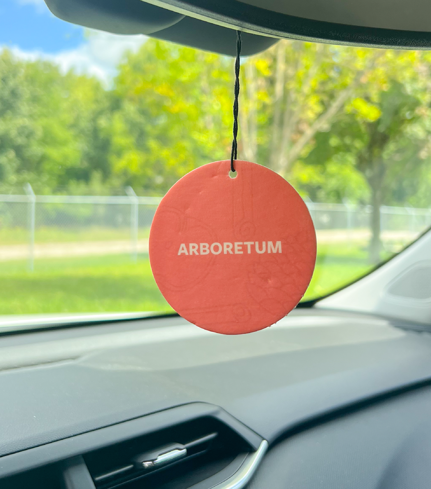 An Arboretum Car Freshener Hanging in a car.