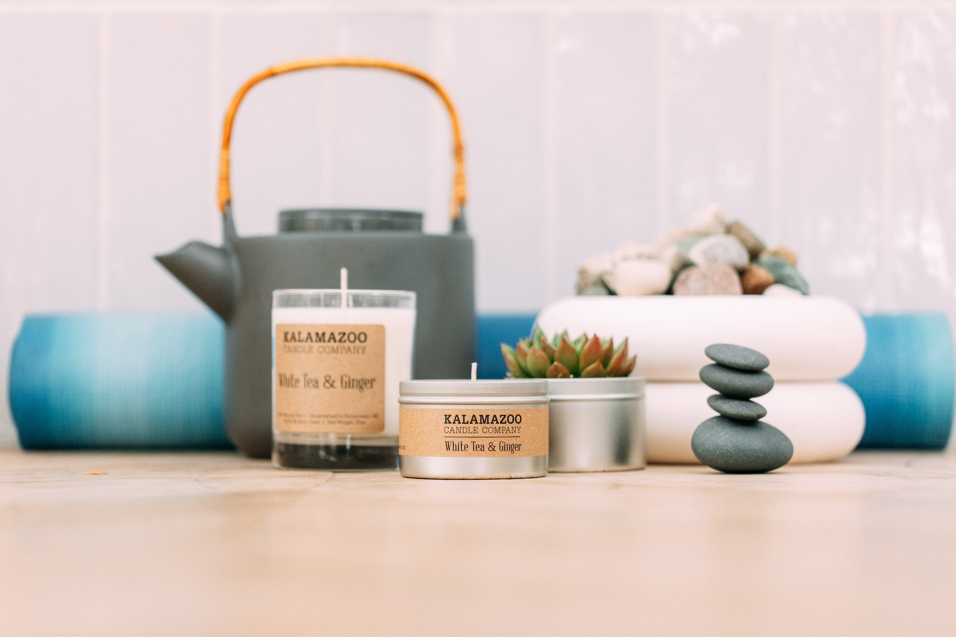 A white tea & Ginger candle next to a tea pot