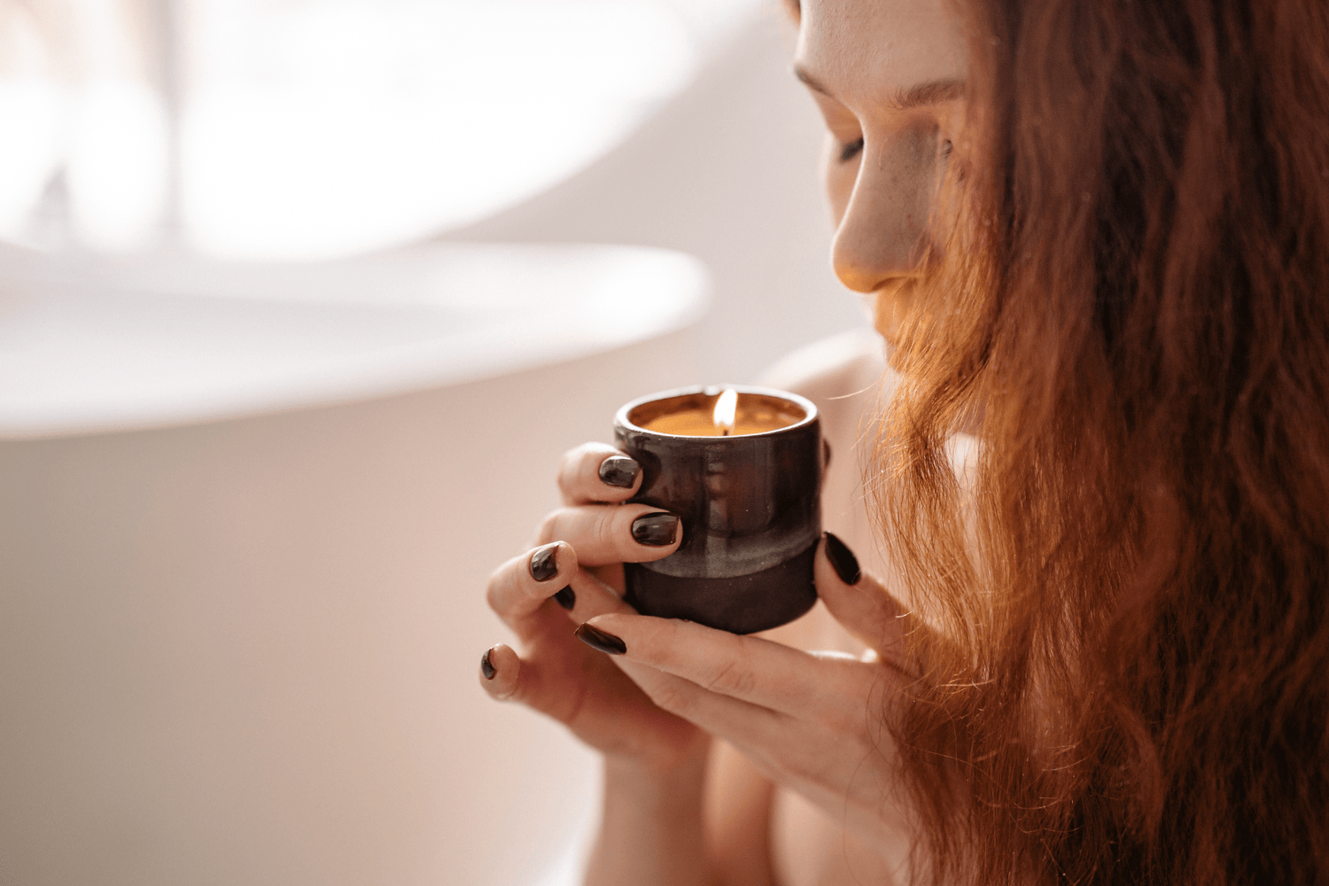 A person smelling a lit candle