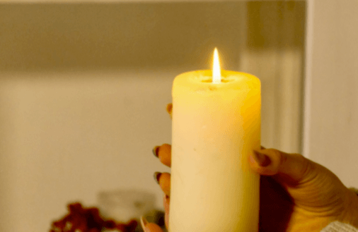 Hand holding burning candle
