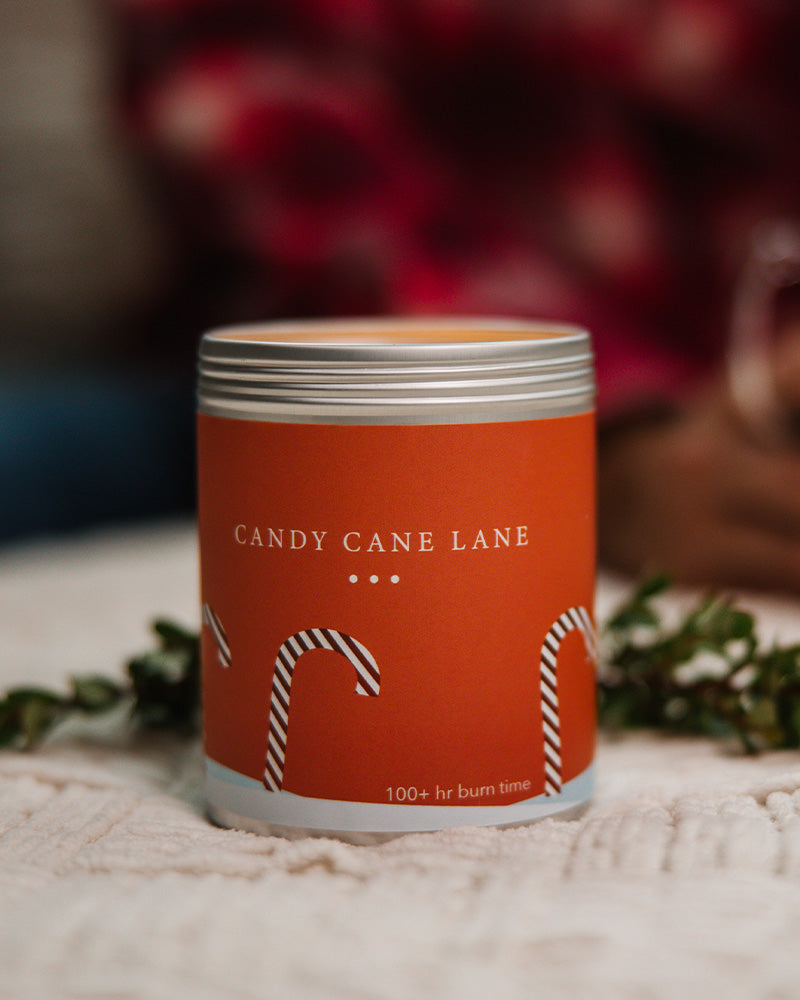 A Large Red Candle Tin with images of Candy Canes on the side. Made in Kalamazoo, MI USA. Scented with Frosted Citrus, Crushed Peppermint, and Sugar.
