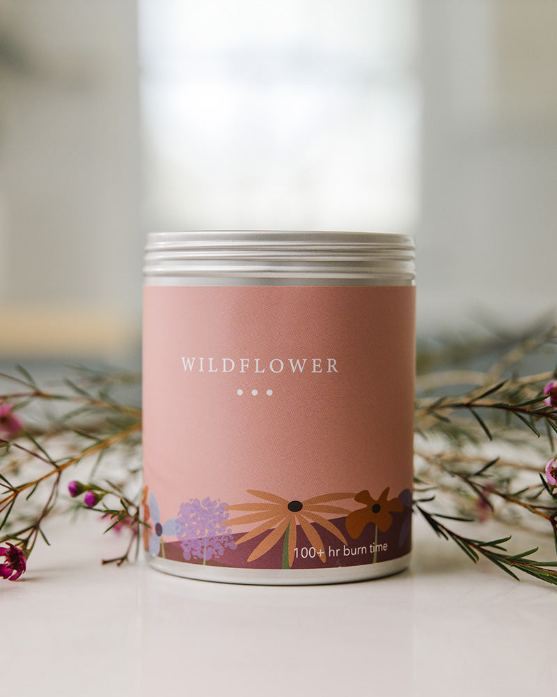 A Large Pink Tin With Wildflowers on the side. Made in The USA In Kalamazoo, MI. Scented with Citrus, Florals, and Vanilla.