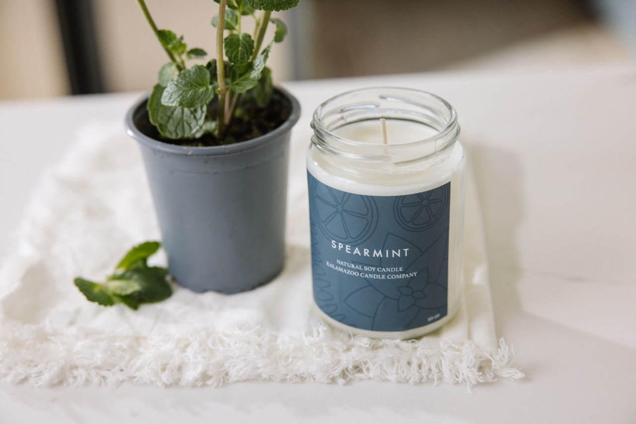 Spearmint Candle on a white blanket.