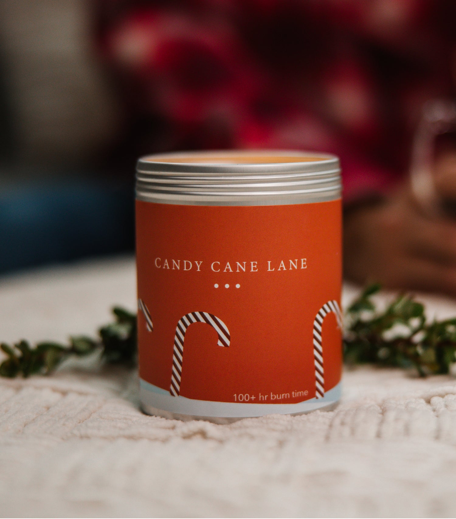 A Large Red Candle Tin with images of Candy Canes on the side. Made in Kalamazoo, MI USA. Scented with Frosted Citrus, Crushed Peppermint, and Sugar.