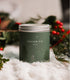 A Large green candle tin with Fir Tree Artwork on the side. Made in Kalamazoo, MI USA. Scented with White Sage, Fresh Pinecones, and Frosted Fir Needles.