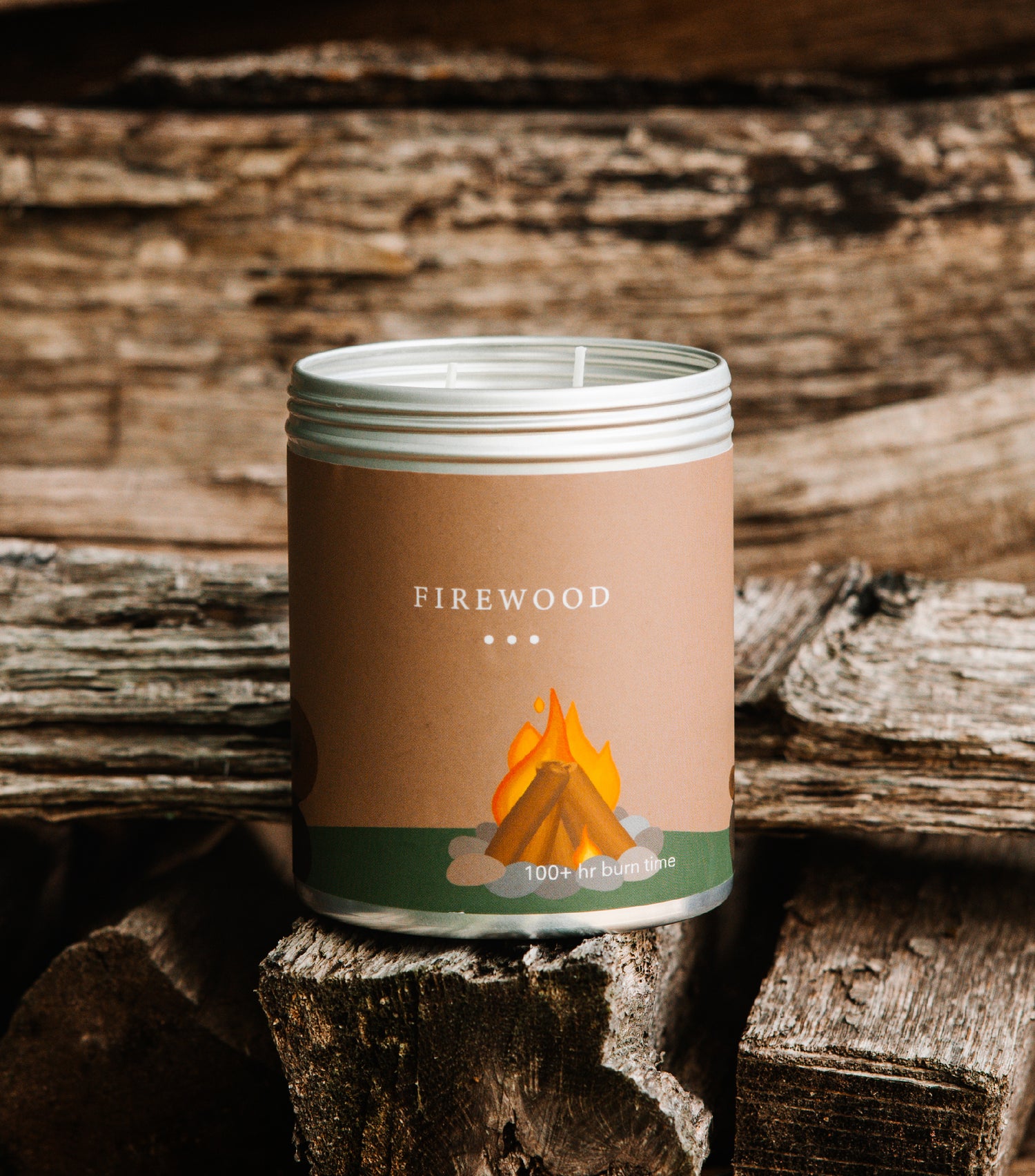 A Large brown tin with an image of a roaring campfire on the side. Made in Kalamazoo, MI USA. Scented with Gilded Spices, Fir Needle, and Smokey Vetiver.