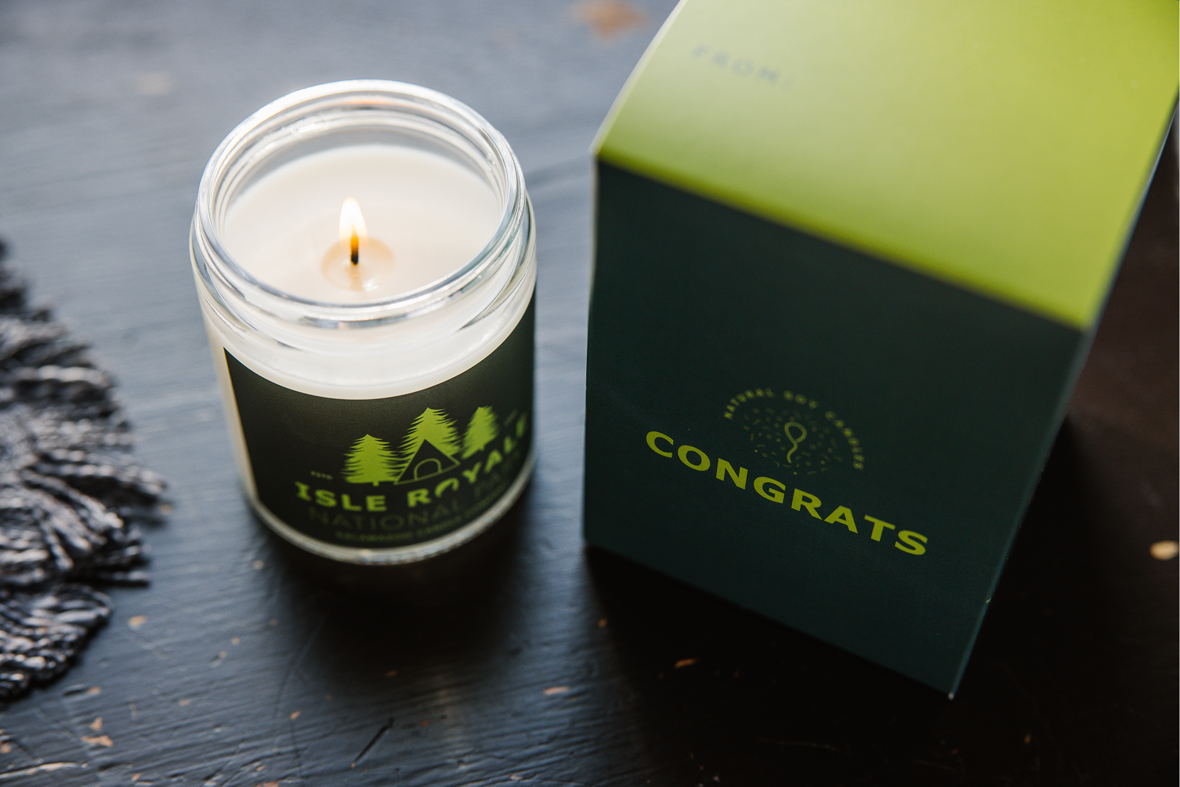 An Isle Royale Candle next to a Congrats Box