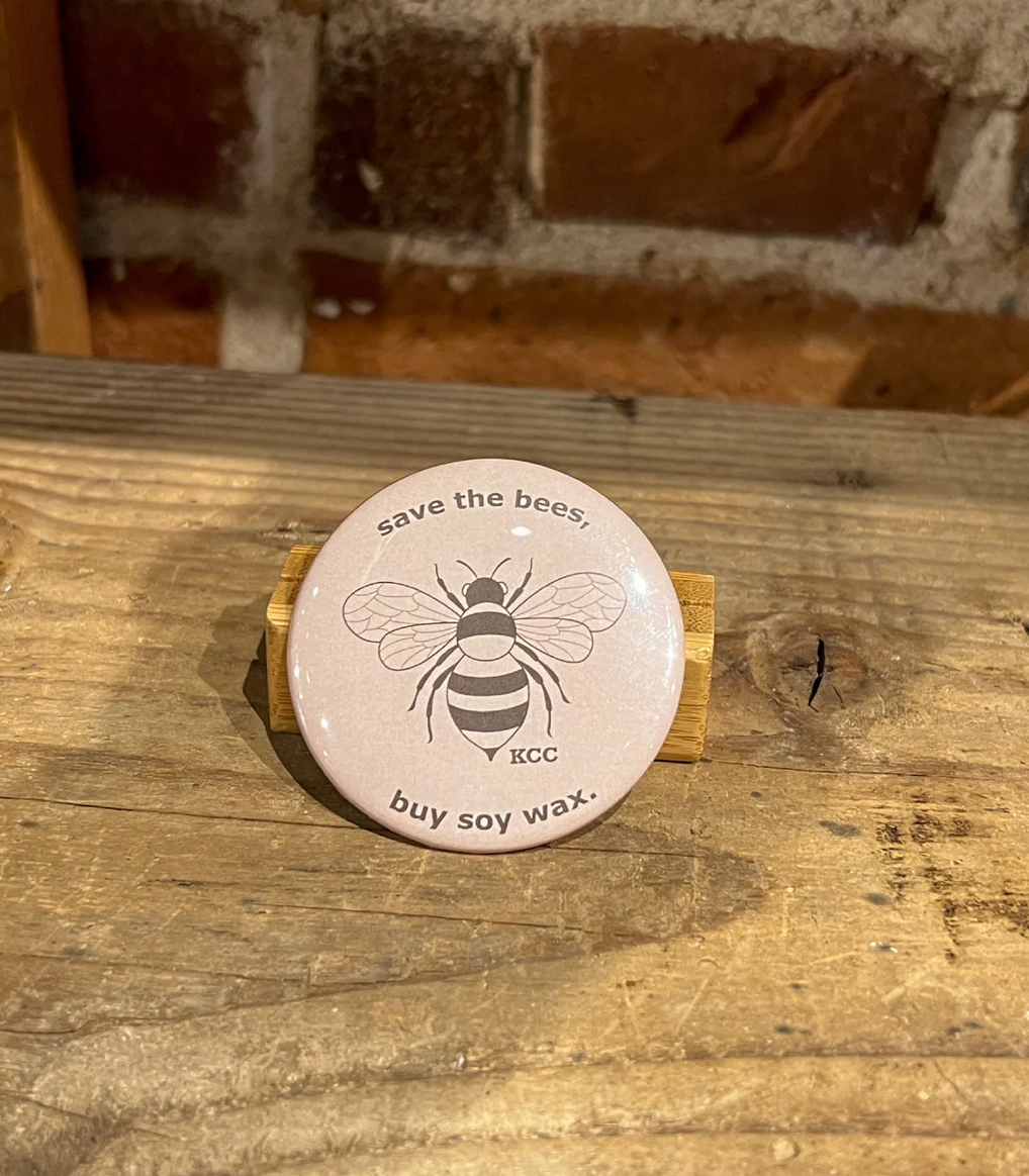 A Tan button with a Bee image that says save the bees, buy soy wax.
