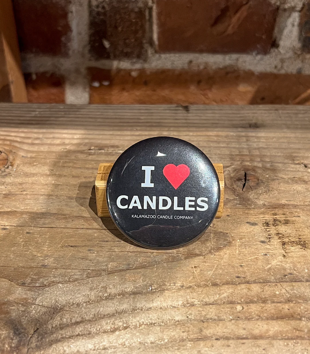 A Black button with a red hear that says I love candles
