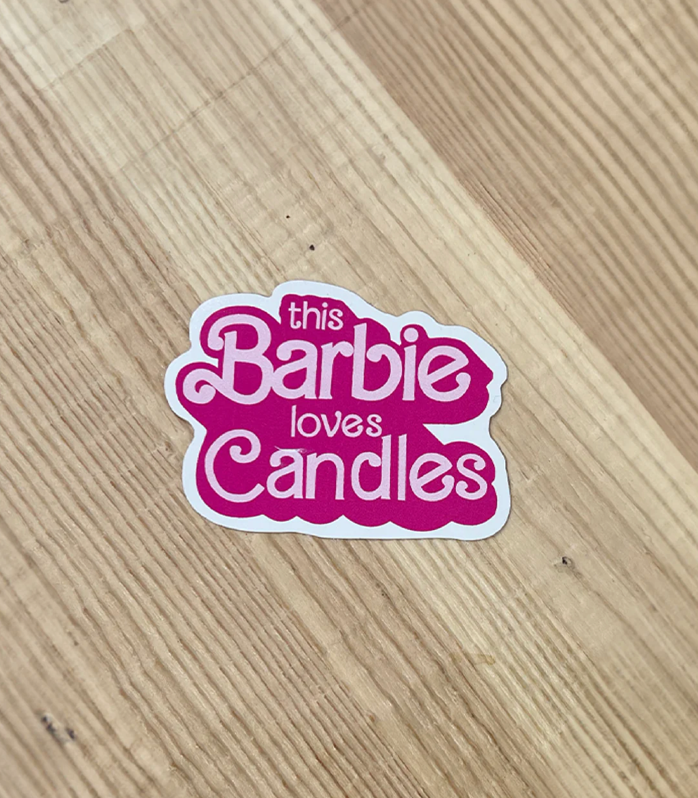 A pink sticker in the Barbie font that says &quot;This barbie loves candles&quot;