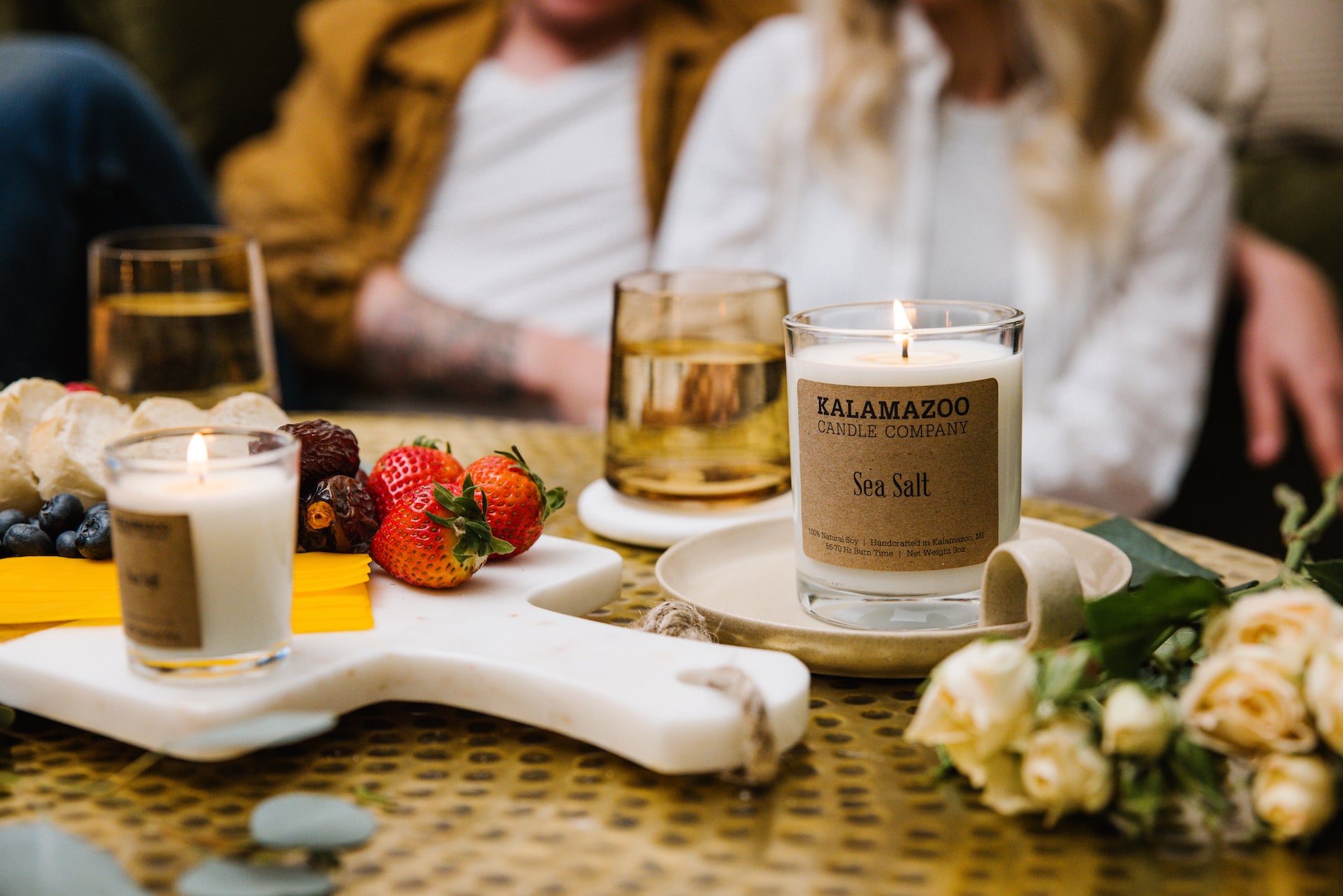 Couple enjoying charcuterie with candles burning