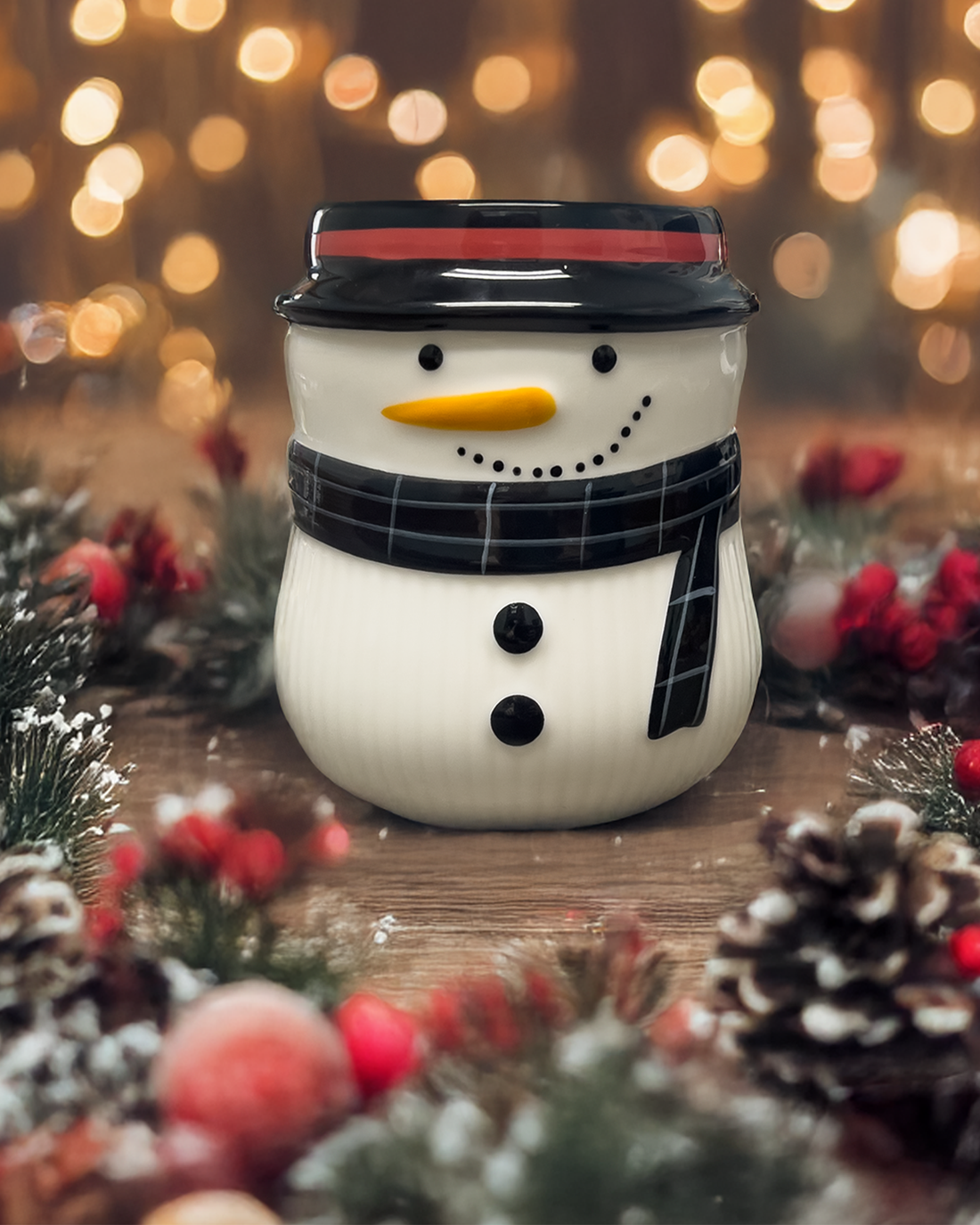 ceramic snowman with candle surrounded by holiday decoration