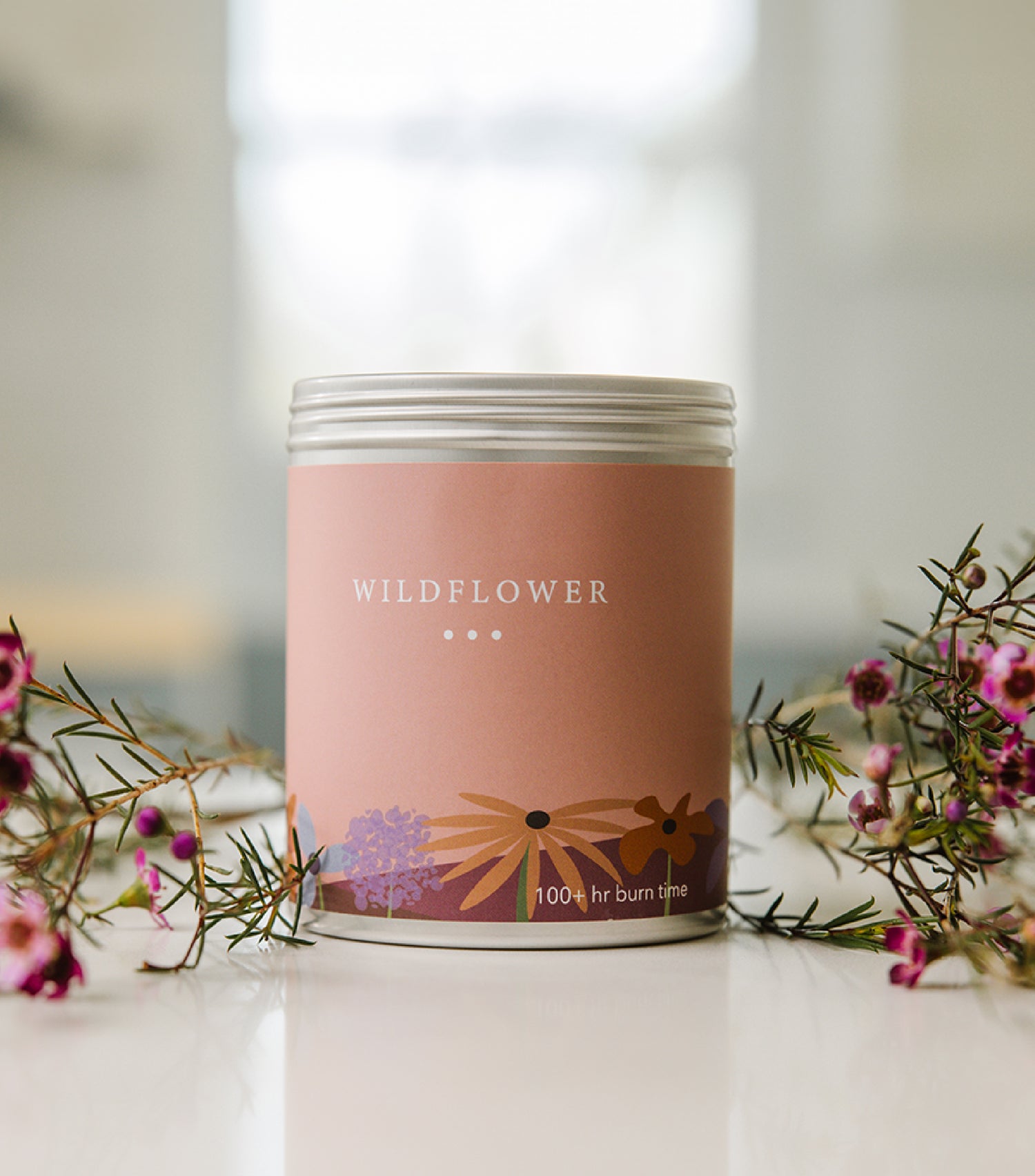A Large Pink Tin With Wildflowers on the side. Made in The USA In Kalamazoo, MI. Scented with Citrus, Florals, and Vanilla.