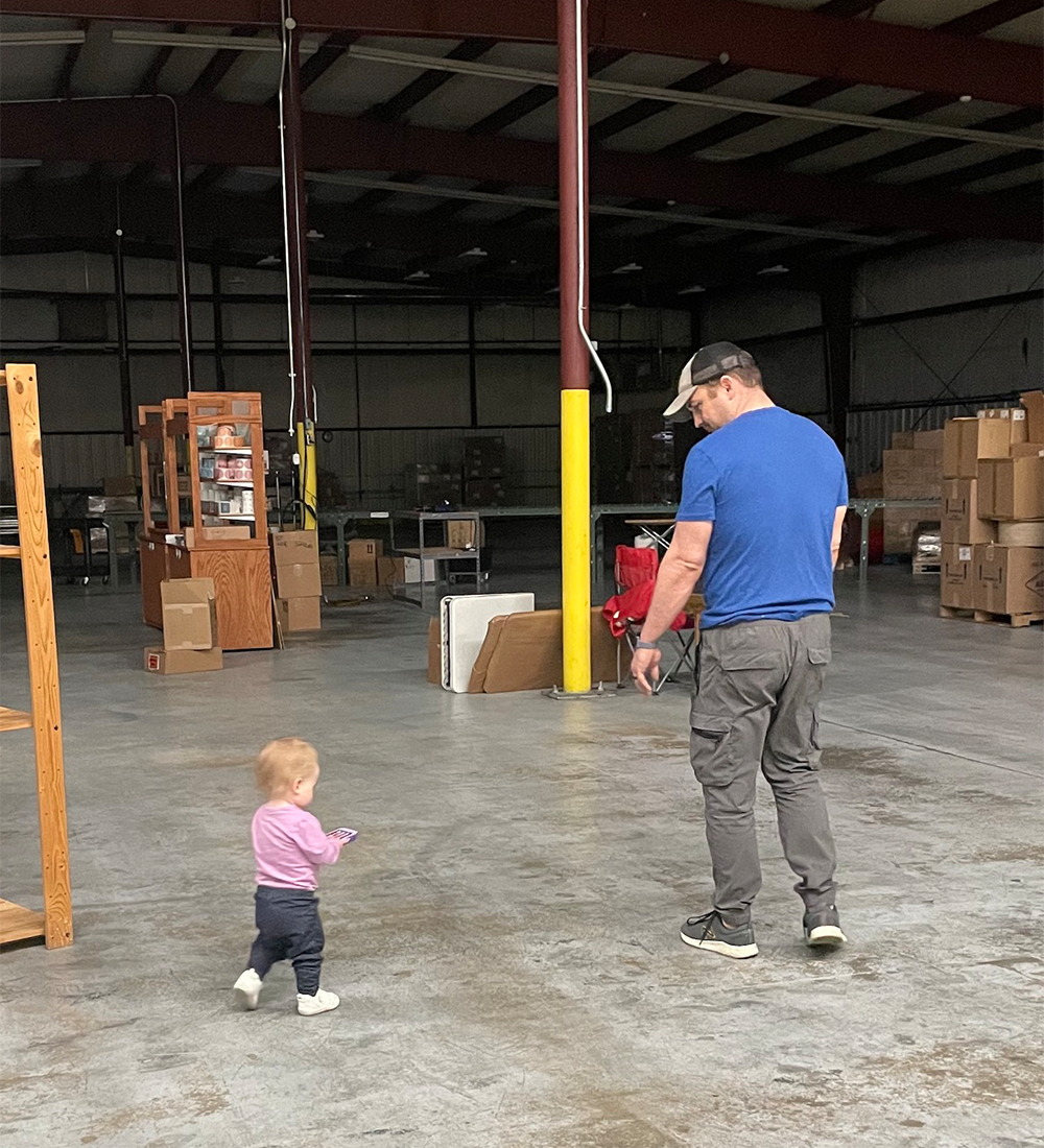 Owner Adam and daughter Maive walking at warehouse