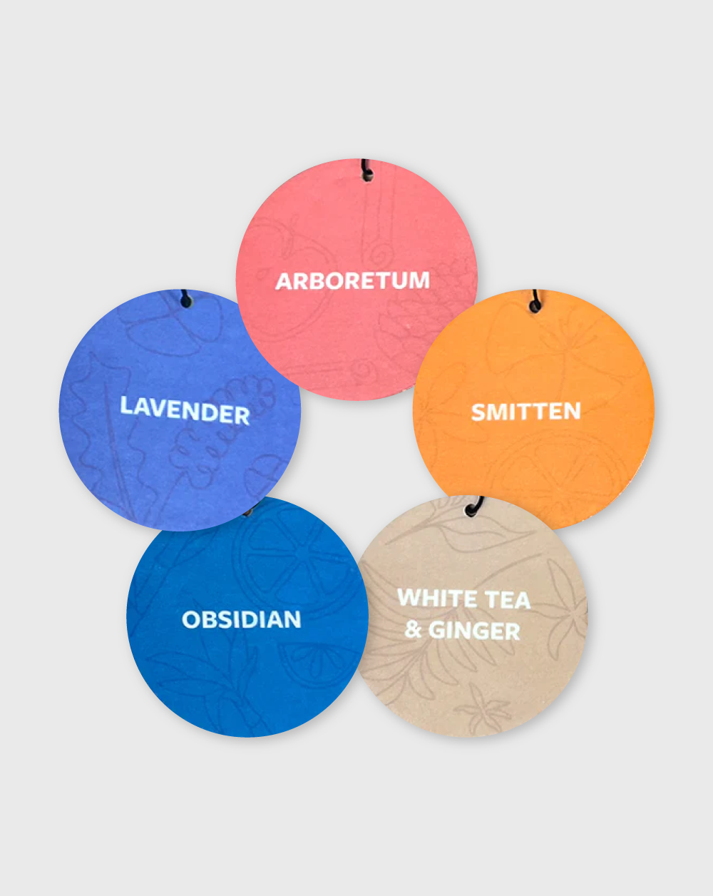 five multi-colored, circular car air fresheners arranged in a circle with the scent names on each one including arboretum, lavender, smitten. obsidian, white tea &amp; ginger