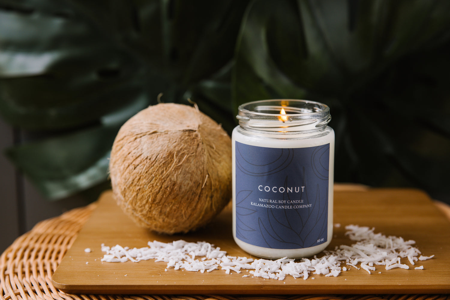 A coconut candle next to a coconut.