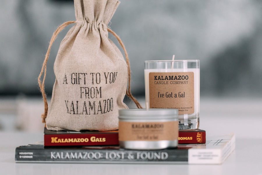 I've Got A Gal soy candle and travel tin with Kalamazoo history books and a 'Gift to You from Kalamazoo' bag