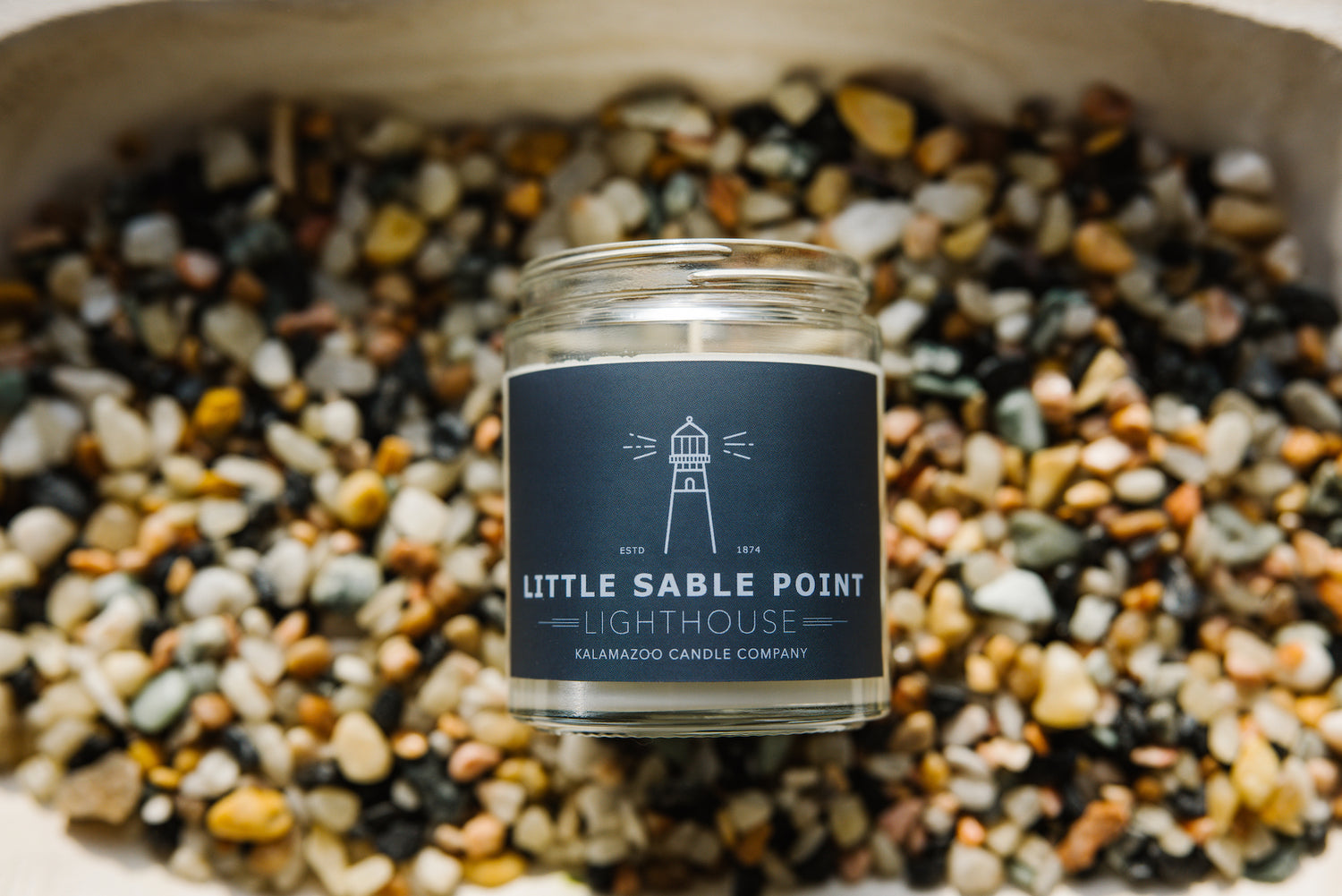 Little Sable Point Candle on a bed of stones