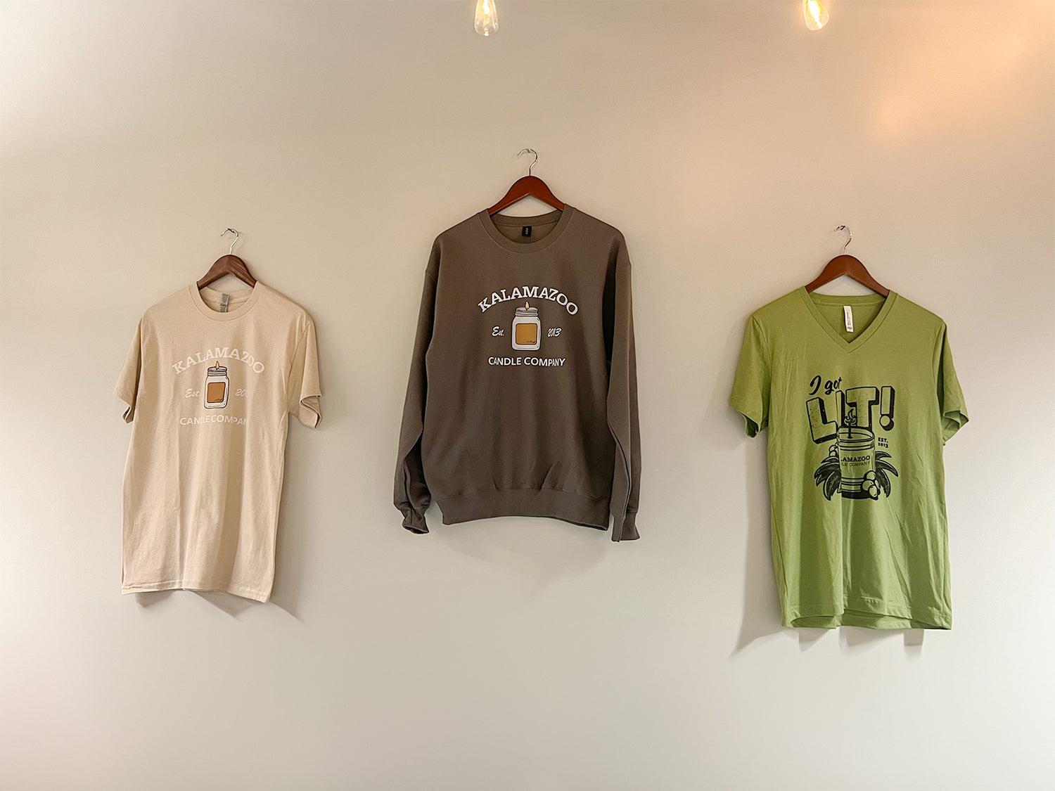 3 Merchandise Shirts hanging on a wall.