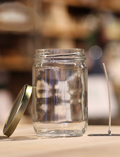 An empty jar with wick and lid.